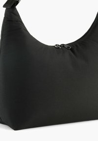 Czarna torebka o zaokrąglonym kształcie, z dwoma czarnymi zamkami błyskawicznymi i miękką, gładką fakturą. Minimalistyczny design bez widocznych wzorów.
