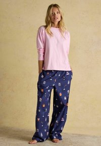 Světle růžový dlouhý rukáv top kombinovaný s volnými námořnickými pyžamovými kalhotami se skládajícími z barevných vzorů zvířat, vyrobený z měkké látky.