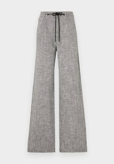 Calças largas cinzentas feitas de tecido texturizado. Apresentam uma cintura elástica com um cordão preto e bolsos laterais.