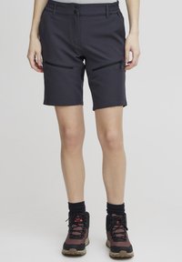 Čierne šortky vyrobené z ľahkého, elasticého materiálu, s dvoma prednými vreckami na zips a elastickým pásom.