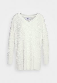 Suéter blanco de punto con cuello en V, que presenta un patrón de diamantes texturizado y detalles de pompones. Manga larga y puños acanalados.