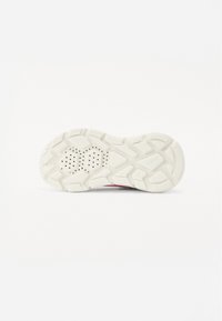 Suola di sneaker bianca con motivo in gomma testurizzata, caratterizzata da forme esagonali e rettangolari, e fori di ventilazione per la traspirabilità.