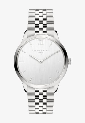 Sølv rustfrit stål ur med en børstet urskive, minimalistisk design og tynde timemarkører. Har en kædet metallrem og krone.