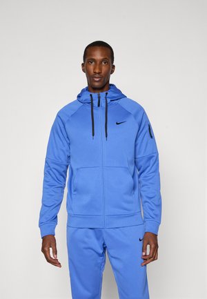 Blauer Reißverschluss-Hoodie aus weichem Stoff mit einem Kängurutasche, gerippten Bündchen und einem schwarzen Nike-Logo auf der Brust. Verfügt über verstellbare Kordeln.