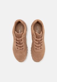Hnědé semišové tenisky s šněrováním, perforovaným designem, polstrovaným límcem a stélkou z paměťové pěny. Ohebná podešev, minimální viditelné logo.