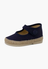 Zapato de lona azul marino con punta redonda, detalle de yute tejido beige contrastante a lo largo de la suela, y una correa ajustable con cierre de botón.