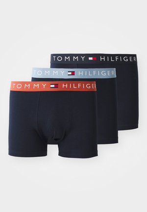 Tre par navy boxer briefs med forskellige taljer: orange, blå og sort, hver med "TOMMY HILFIGER" logoet i hvid.