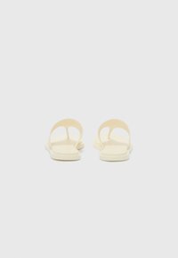 Yellow flat sandals with a minimalist design, featuring an open toe and back, made of smooth material, with flat soles and no embellishments.
