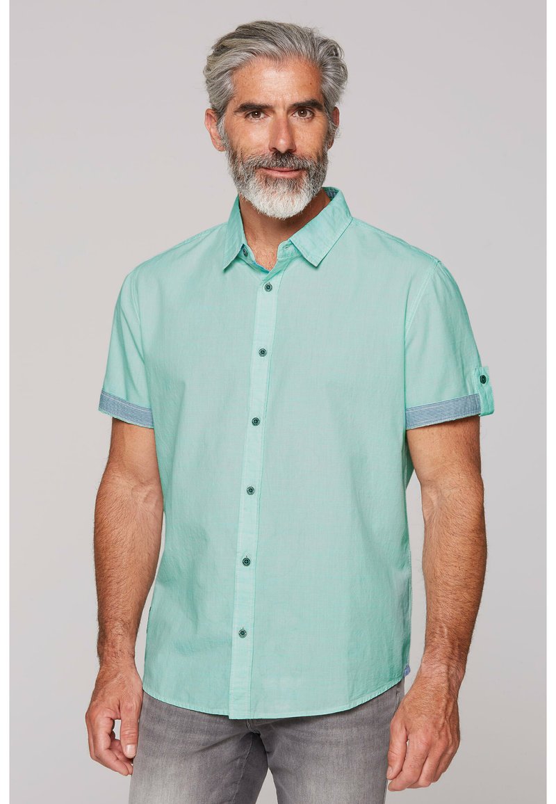 Camicia a maniche corte verde chiaro con colletto a punta. Presenta un tessuto a strisce blu contrastante sui polsini e sui bottoni.