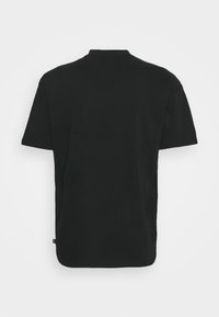 Czarny t-shirt z krótkim rękawem, okrągłym dekoltem, luźnym krojem, gładką fakturą oraz małą metką marki na lewej stronie u dołu.