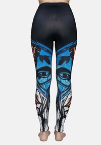 Zwarte leggings met een levendig grafisch ontwerp met blauwe en oranje accenten. Het patroon bevat ogen en abstracte vormen.