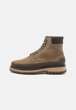 Brown suede hiking boot with a contrasting dark brown leather collar, sturdy rubber sole, and metal eyelets for laces.