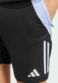 Mustat urheilushortsit, jotka on valmistettu sileästä kankaasta. Shortsien sivuissa on vaaleansiniset paneelit ja valkoiset Adidas-raidat, joissa on logo helmassa.