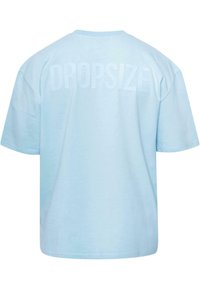 Lyseblå, oversized t-shirt lavet af bomuld. Har en stor prægede "DROPSIZE" tekst på ryggen. Rund hals og korte ærmer.