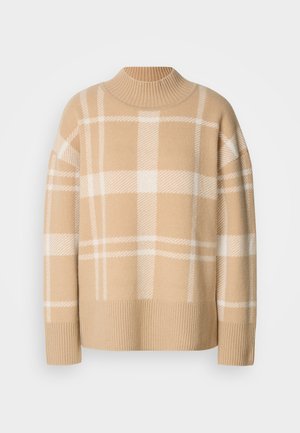 Beige pulóver fehér kockás mintával, bordás kerek nyakkivágással és mandzsettával. Puha tapintású, esett vállakkal és laza fazonnal.