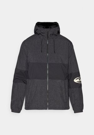 Jakna na zatvarač s kapuljačom, izrađena od crnog materijala s uzorkom rešetke i čvrstim crnim panelom. Uključuje logotip na desnoj rukavu.