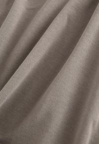 Tessuto marrone con una consistenza liscia, caratterizzato da sottili pieghe e un motivo di tessitura uniforme, che riflette delicatamente la luce sulla superficie.