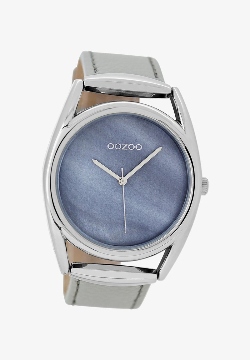 Montre argentée avec un cadran rond en marbre bleu, aiguilles des heures et des minutes en argent, et un bracelet en cuir gris avec des accents métalliques.