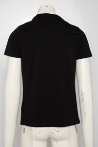 Juodas medvilninis marškinėlis ant manekeno, trumpomis rankovėmis ir klasikine apvaliomis kaklo linija, su lygiu, ribotu paviršiumi.
