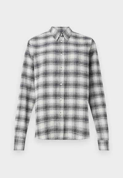Košeľový vrch v čierno-bielej kockovanej vzore, vyrobený z mäkkej tkaniny, s golierom a dlhými rukávmi so zapínaním na gombíky.