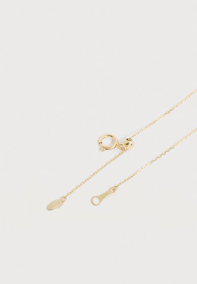 Λεπτό κολιέ αλυσίδας από χρυσό με κούμπωμα ροδέλας και δύο μικρές χαραγμένες ετικέτες σε απλό ανοιχτό φόντο.