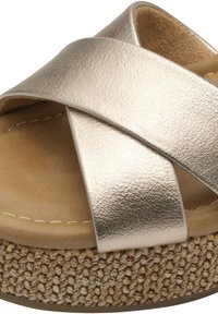 Sandalia de tiras cruzadas metálica dorada con una plataforma de corcho texturizada. Plantilla suave en beige con costuras visibles y detalles woven en la suela.
