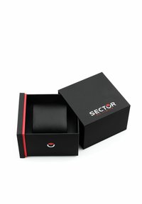 Scatola regalo rettangolare nera con accenti rossi e logo "SECTOR NO LIMITS". Contiene un oggetto cilindrico liscio e nero all'interno.