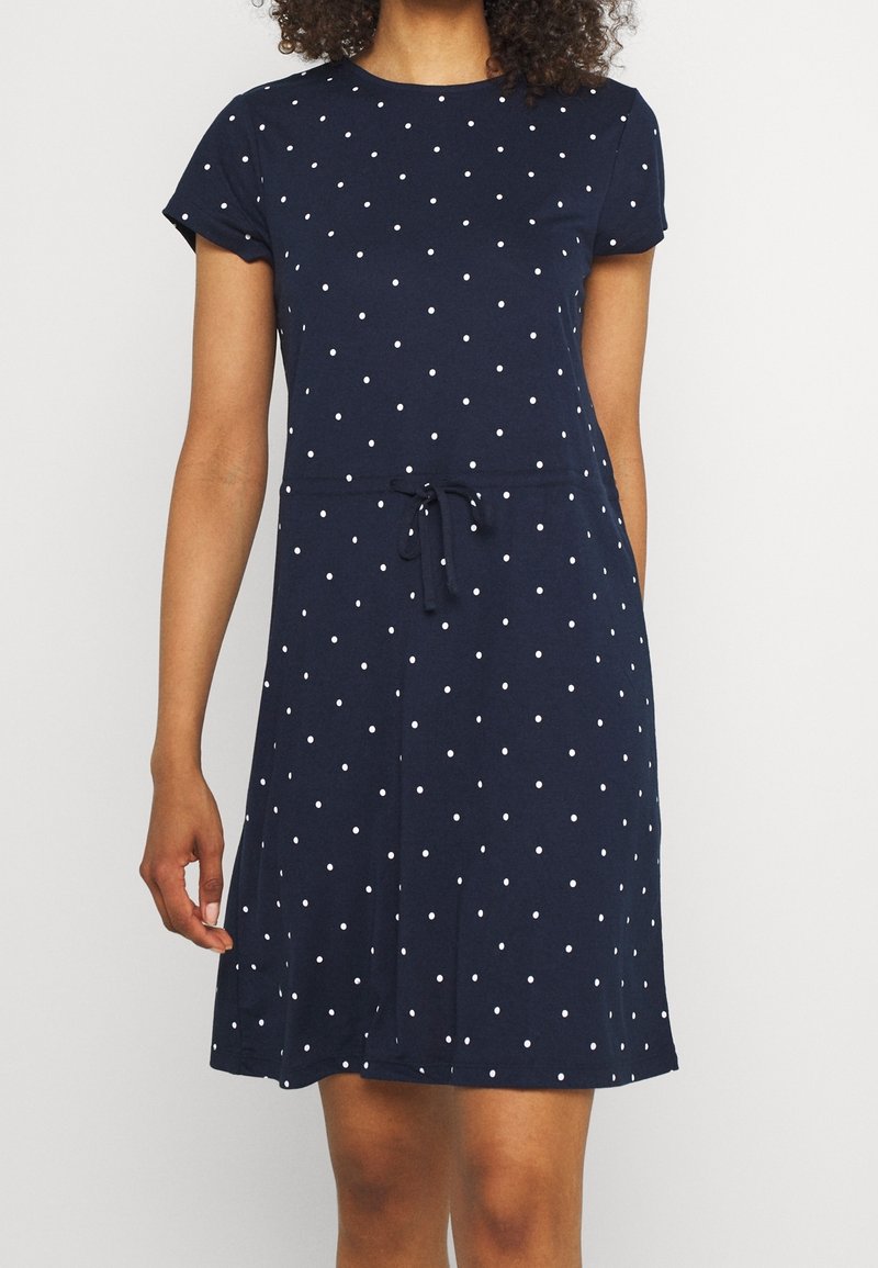 Robe bleu marine en coton doux, dotée d'un col rond, de manches courtes, de pois blancs et d'un détail de taille à cordon.
