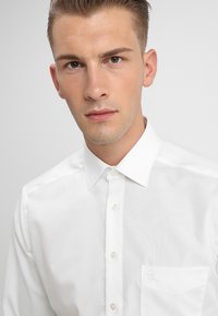 Witte overhemd met kraag, gemaakt van een gladde stof, met knoopsluiting en een enkele borstzak, in een klassieke, op maat gemaakte pasvorm.