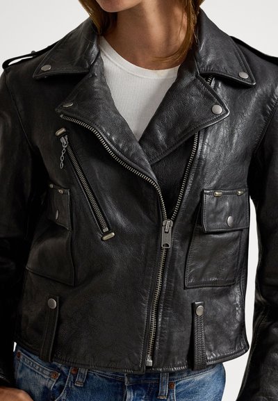 Crna kožna motoristička jakna s teksturiranim završetkom, asimetričnim patentnim zatvaračem, više prednjih džepova i srebrnim ukrasnim detaljima.