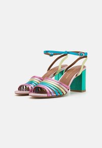 Sandal con tacco alto e cinturini, caratterizzata da cinturini metallici multicolor, una zona piedi rosa e un tacco a blocco turchese con finitura texturizzata.