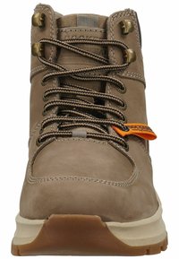 Braune Leder-Wanderschuhe mit gepolsterter Knöchelpartie, Metallösen und einem kontrastierenden orangefarbenen Etikett. Texturierte Oberfläche und Gummisohle für Halt.