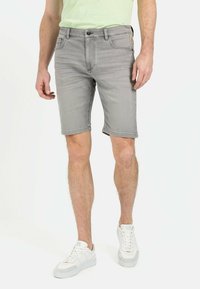 Graue Jeansshorts mit fünf Taschen, Knopfverschluss und umgeschlagenem Saum; kombiniert mit weißen Sneakern. Baumwollmischgewebe mit lässigem Design.