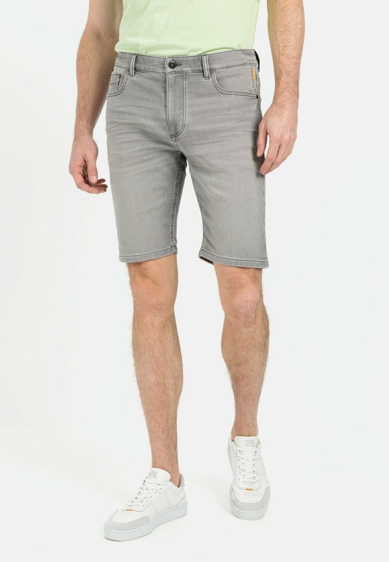 Graue Jeansshorts mit fünf Taschen, Knopfverschluss und umgeschlagenem Saum; kombiniert mit weißen Sneakern. Baumwollmischgewebe mit lässigem Design.