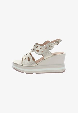 Sandalia cuña beige con empeine de piel recortado, correa ajustable con hebilla y suela de plataforma estratificada.