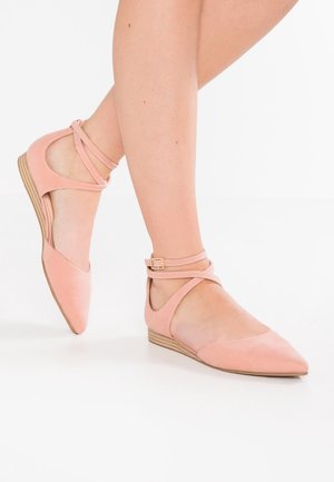 Pink suede flats with a pointed toe, ankle strap, and cutout design, featuring a low wooden wedge heel. Smooth texture with minimal accents.