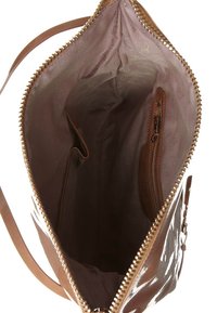 Das Innere einer braunen Lederhandtasche mit glatter Textur, einem Reißverschlussfach und einer hellen Stoffauskleidung mit dezenten Mustern.