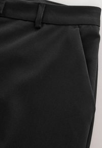 Black trousers made from a smooth, slightly textured fabric, featuring a flat front, side pockets, and a standard waistband.