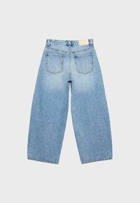 Jean en denim bleu clair à jambes larges vu de dos, avec deux poches arrière et un patch en cuir de marque sur la ceinture.