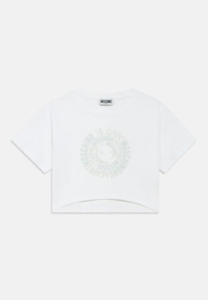 Hvid cropped Moschino t-shirt med korte ærmer og et cirkulært logo i midten med gentaget mærkenavnstekst.