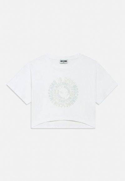 T-shirt court blanc Moschino avec manches courtes et un logo circulaire au centre affichant le nom de la marque en répétition.