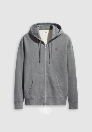 Grijze zip-up hoodie gemaakt van zacht materiaal, met een front pocket, ribgebreide manchetten, en een capuchon met trekkoord. Klein rood logo op de linkerborst.