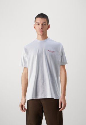 Weißes Baumwoll-T-Shirt mit Rundhalsausschnitt, kurzen Ärmeln und rotem Schriftzug "On Vacation Club" auf der linken Brustseite.