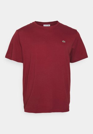 T-shirt en coton bordeaux à manches courtes avec col rond et petit logo crocodile vert Lacoste sur la poitrine gauche.