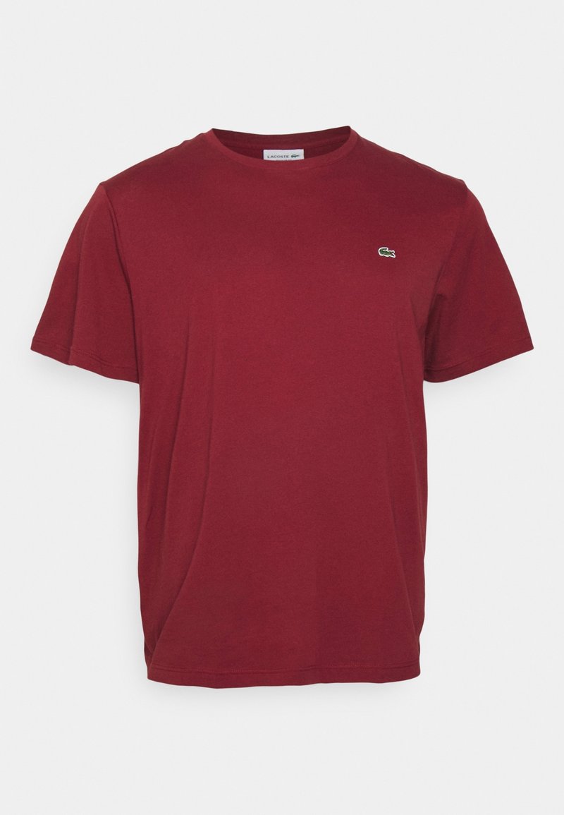 T-shirt en coton bordeaux à manches courtes avec col rond et petit logo crocodile vert Lacoste sur la poitrine gauche.