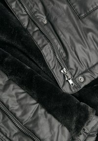 Svart faux läderjacka med en mjuk svart fleece-foder, som har en dubbel dragkedjestängning och tryckknappdetalj vid kragen.