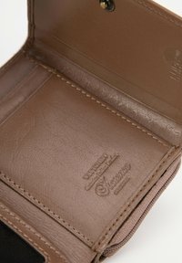 Interieur van een bruine leren portemonnee met een gladde textuur, gestikte randen, gegraveerde branding en een drukknoopsluiting.