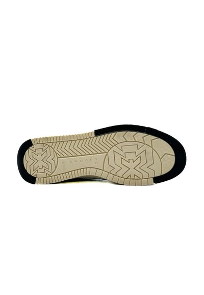 Suola di una sneaker con una base in gomma beige testurizzata e un accento in gomma nera all'apice, dotata di motivi geometrici per una migliore aderenza.