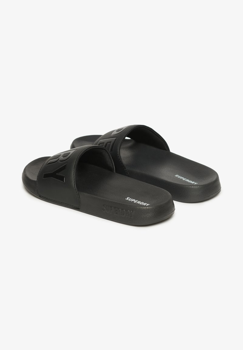 Sorte sandleder lavet af syntetisk materiale med brede stropper med præget branding. Glat tekstur og let design.