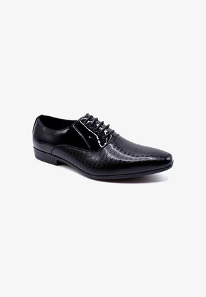 Chaussure de dress en cuir noir avec un bout pointu, présentant des lignes diagonales texturées et un laçage décoratif. Fini lisse avec un léger éclat.